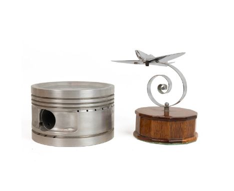 Chrome model Spitfire on wooden base, plane L 14cm, H 16cm. Together with an original aluminium piston from a Vulcan bomber, 