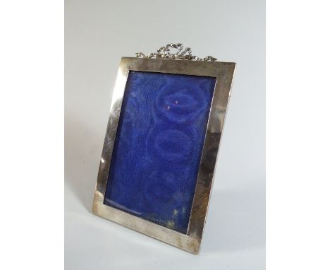 A Silver Mounted Rectangular Photo Frame with Ribbon Finial. London 1908. 22cm High