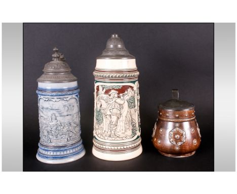Three German Antique Stoneware Steins With Pewter Tops, one depicting a man blowing a hunting horn, Heidelberg, and brown sto