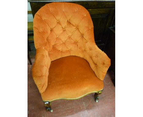 A late Victorian button upholstered armchair on carved front supports and castors, 89 x 67 cms