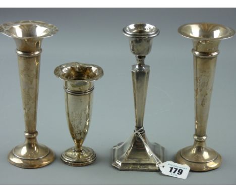 Three hallmarked silver trumpet bud vases and a single candlestick, various hallmarks, all loaded bases (impact damage and cr