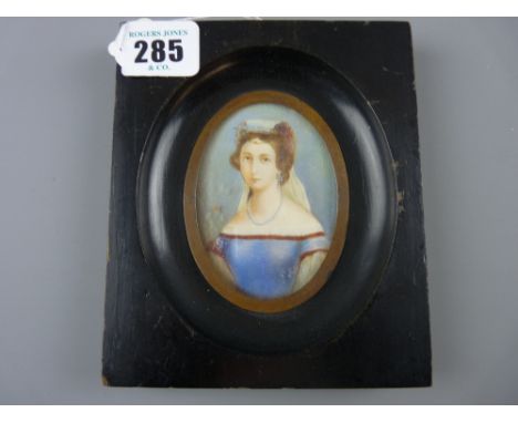 A miniature half length portrait of a young woman in classical dress, watercolour on ivory slip in an ebonized frame, circa 1