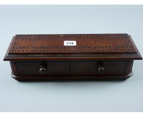 A Victorian rosewood cribbage board with two lower drawers on bun feet, 9.5 x 34 cms