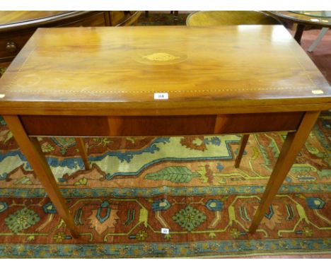 A reproduction yew oblong topped foldover baize lined card table, the top having a fine oval shell inlay and with ebony and l