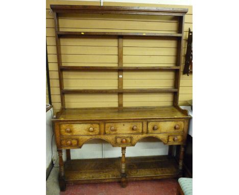 A George III oak South Wales borders dresser with open back three shelf Delft rack, full length shoe on a three board top ove