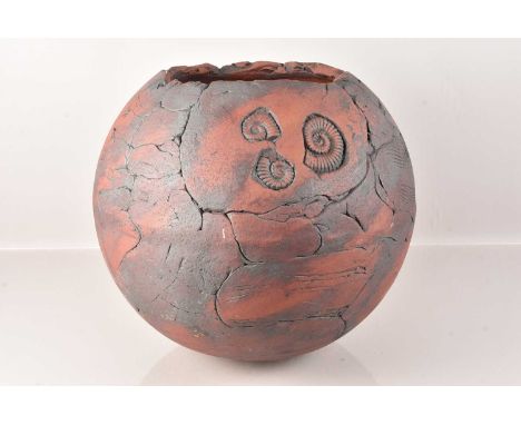 A large stoneware pot, having three ammonite design to the front, 39cm H