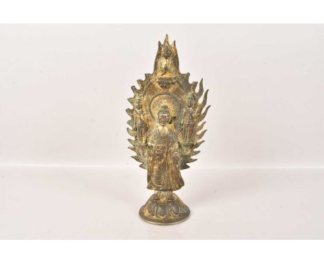 A Chinese Archaic Bronze Figure of Standing Buddha, fronting a torana flanked by standing attendants, below a seated Buddha, 