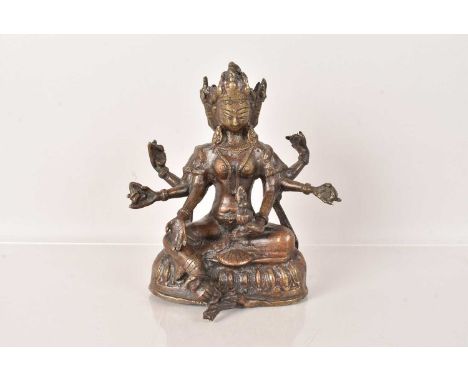 A Tibetan Bronze Female God Figure, possibly Jnana Dakini, having three heads and six arms, in the seated position, 16cm Hlig