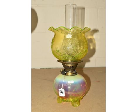 A TWIN BURNER OIL LAMP, having vaseline and cranberry glass reservoir, yellow glass floral feet, yellow glass shade having fl