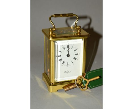 A MODERN BRASS CASED WOODFORD OF ENGLAND CARRIAGE CLOCK, glazed sides, back and top, white painted dial with Roman and Arabic