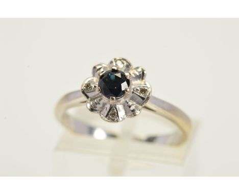 A SAPPHIRE AND DIAMOND RING, designed as a central circular sapphire within an undulating single cut diamond surround, stampe