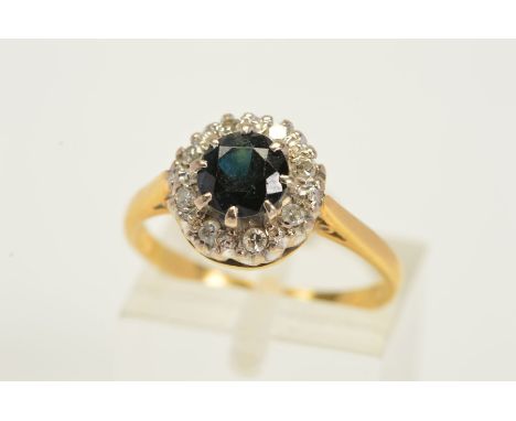 AN 18CT GOLD SAPPHIRE AND DIAMOND CLUSTER RING, designed as a central circular sapphire in an eight claw setting, within a si