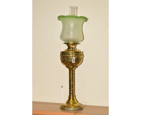 A BRASS ART NOUVEAU STYLE OIL LAMP, with embossed reservoir, frosted shade and clear glass chimney, approximate height 62cm n