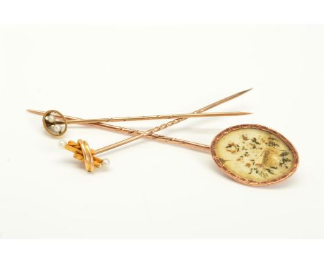 THREE STICKPINS, the first a late Georgian stickpin, the oval terminal encasing dried pieces of foliage, together with two la