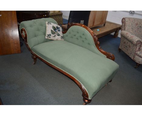 A VICTORIAN WALNUT CHAISE LONGUE, with an arched back and large scrolled arms, on large flat cylindrical feet and ceramic cas
