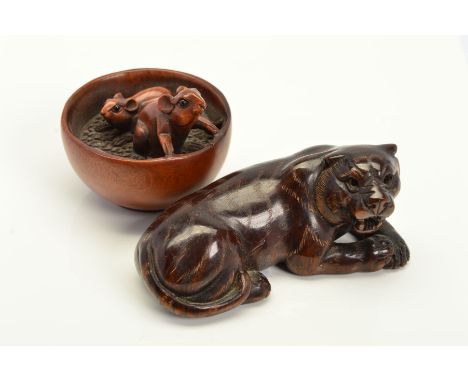 TWO ORIENTAL WOOD NETSUKES, the first carved to depict a tiger laying down, the second a bowl with rats inside, lengths 42mm 
