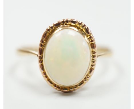 A yellow metal and oval white opal set ring, size Q, gross weight 2 grams.