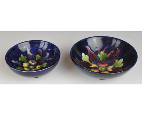 Two Moorcroft pedestal dishes decorated in the Clematis pattern, with Queen Mary paper labels to bases, largest diameter 11.5