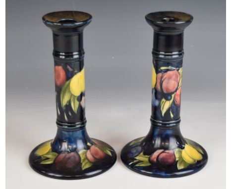 Moorcroft pair of signed candlesticks decorated in the Wisteria pattern, H19cm