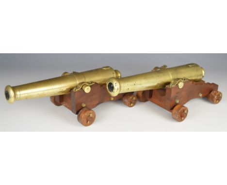 A pair of bronze desk or signalling cannon each, with 13 inch graduated barrel on wooden carriage, 35cm long.