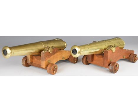 A pair of bronze desk or signalling cannon, each with 13 inch graduated barrel on wooden carriage, 35cm long.