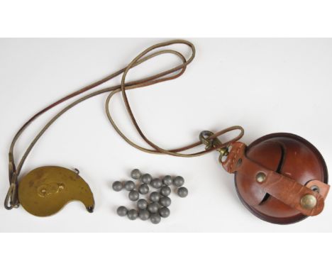 Brass rotary percussion cap dispenser stamped 'TDC' and a leather musket ball holder.&nbsp;