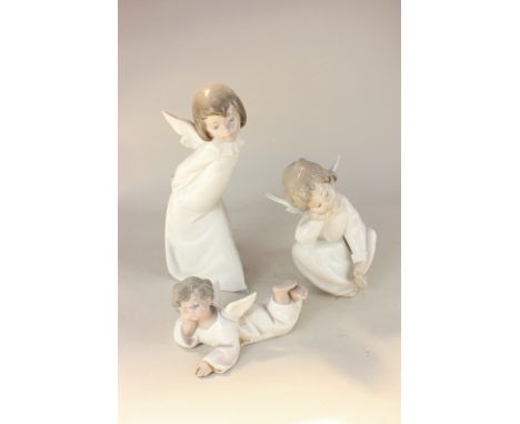 Three Lladro porcelain figures of child angels standing, sitting and lying, tallest 24.5cm