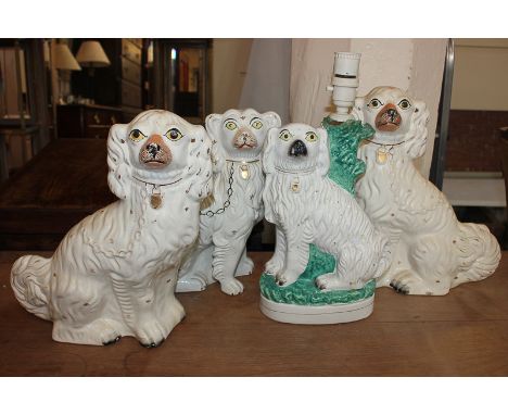 A pair of Staffordshire models of spaniels, 33cm, another single spaniel, and one converted to a table lamp (a/f)