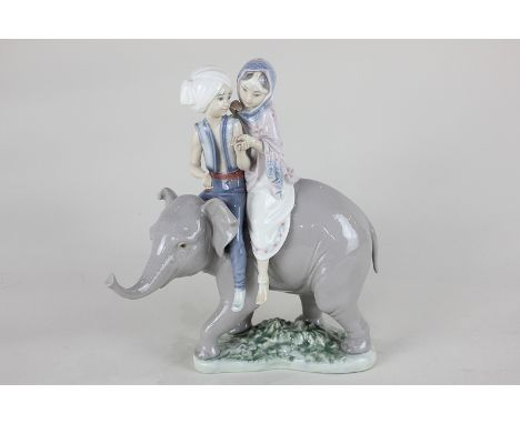 A Lladro porcelain figure group of Hindu children, a boy and a girl, riding an Indian elephant, sculpted by Jose Puche, 23cm 