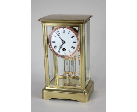 A brass rectangular mantel clock, three inch white enamel dial with Roman numerals, and mercury pendulum, in four glass panel