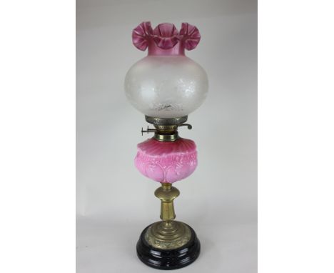 A Victorian brass oil lamp with pink glass well, the wick mechanism marked Duplex with frosted etched glass shade 60cm