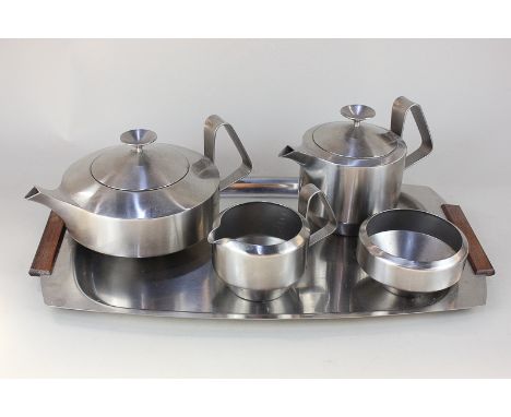 A Robert Welch five piece stainless steel tea set comprising teapot, hot water jug, cream jug, sugar bowl and serving tray wi