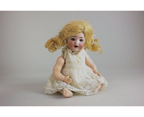 A Kammer & Reinhardt bisque head baby doll marked K star R No 22, with sleeping brown eyes, open mouth and blonde human hair,