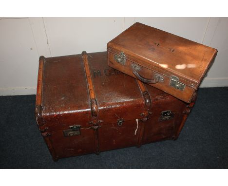An early 20th century traveller's trunk, rectangular shape with metal mounted wooden support, leather carry handles and stenc