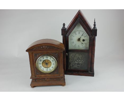 A walnut cased mantel clock with domed cornice and foliate carved decoration, the circular dial with Arabic numerals, 23cm, t