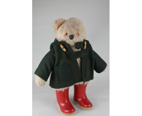 A Gabrielle Designs Paddington Bear soft toy, with label dated 1974, dressed in green duffel coat and red Dunlop Wellington b