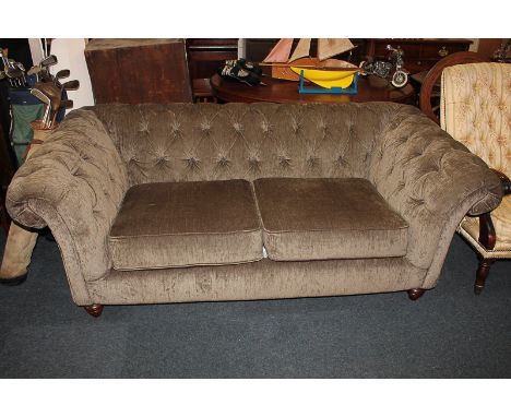 A modern Chesterfield sofa with button upholstered back and arms, two-cushion seat, on turned feet, 190cm