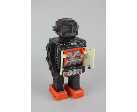 A Japanese circa 1970's tin plate and plastic mechanical toy robot with chest cavity revealing guns, 23cm, (a/f)