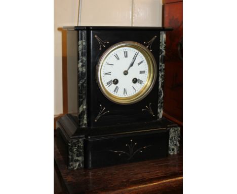 A Victorian black slate mantel clock with green marble trim, the dial with Roman numerals, the French movement striking on a 