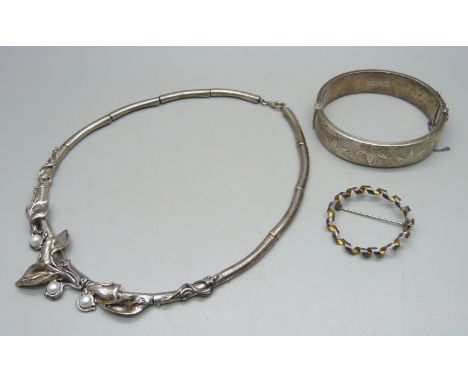 A silver Art Nouveau style necklace set with pearls, a white metal brooch and a silver bangle, dented, 75g 