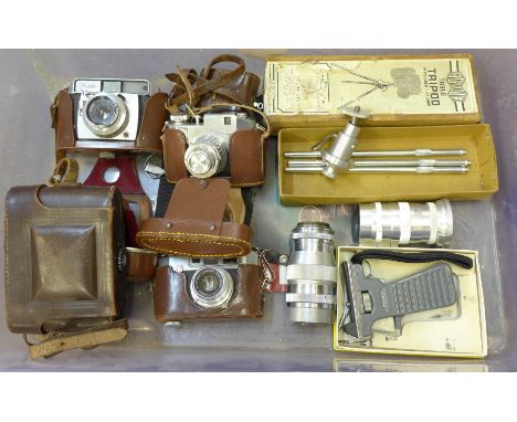 A box of vintage photographic equipment; four cameras, a Komura 3.5 135mm lens, tripod and light meter 