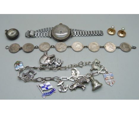 A silver charm bracelet with silver and white metal charms, a silver cased wristwatch, a bracelet made of 8 Indian coins, a s