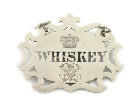 A Victorian silver wine label, by George Adams, London 1873, pierced shaped oval form, pierced 'WHISKEY', engraved with a cro