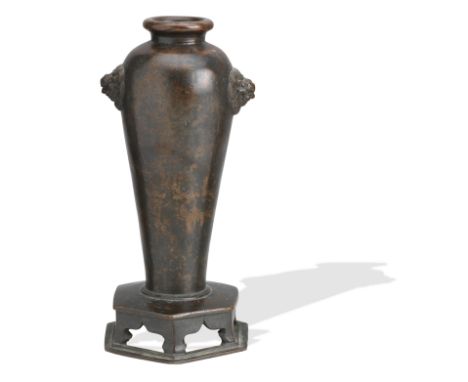A bronze vase on integral stand17th/18th centuryOf baluster form with short neck and twin lion mask handles in relief, all ra