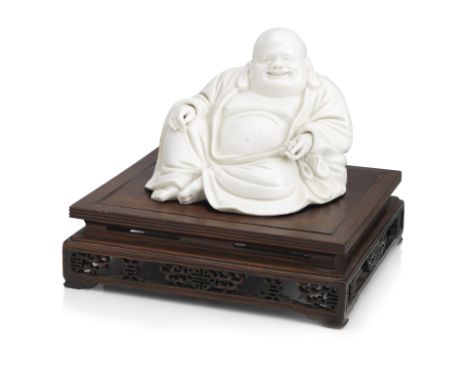 A well-modelled blanc-de-chine figure of Budai on wood standEarly Qing DynastyThe reclining Chan monk wearing thickly-folded 