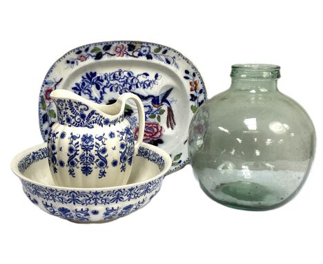 A large glass vintage Carboy, together with a stone china meat ashet and a large blue and white jug and basin set (4)