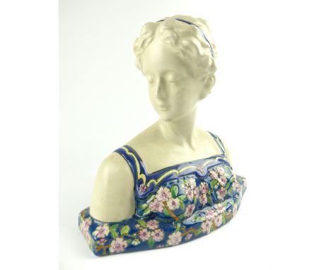 Longwy style bust of a young woman wearing a floral dress, her hair dressed with ribbons and looking to her right, 26cm h