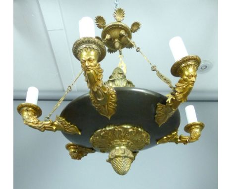 French Empire style ceiling light, the bronzed disk with acorn finial and drop with six green man mask branches to the girdle