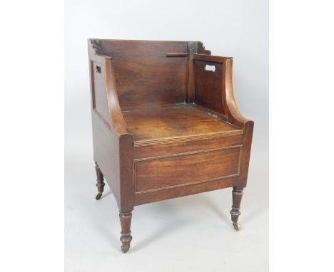 A Georgian mahogany boxed side commode armchair with pierced flanks, turned legs and brass cup castors.