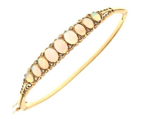 9ct gold and opal snap bangle, of nine graduated cabochons, 10.4g gross approx